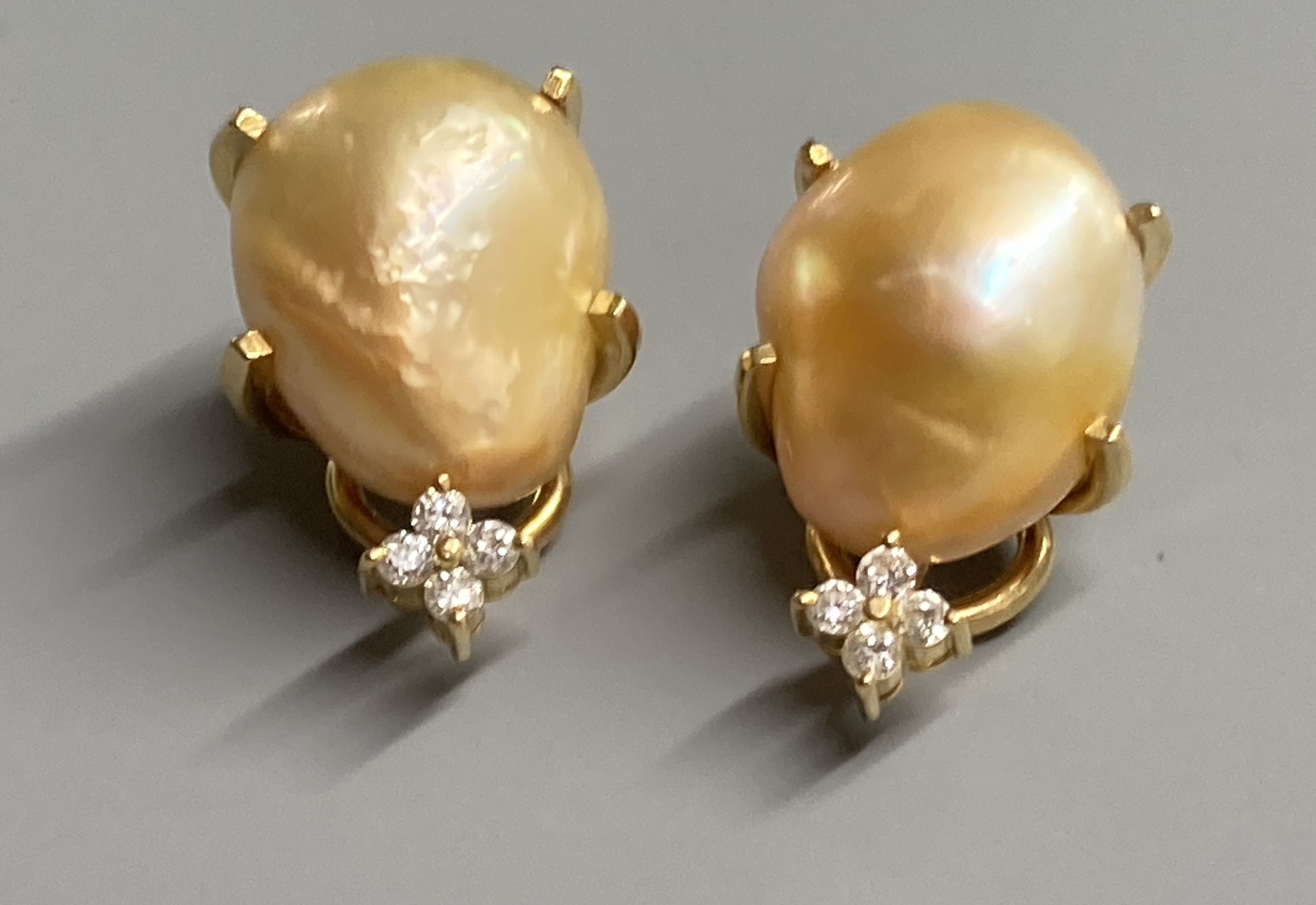 A modern pair of 18k yellow metal, baroque pearl and four stone diamond chip set ear clips, 21mm, gross 9.7 grams.